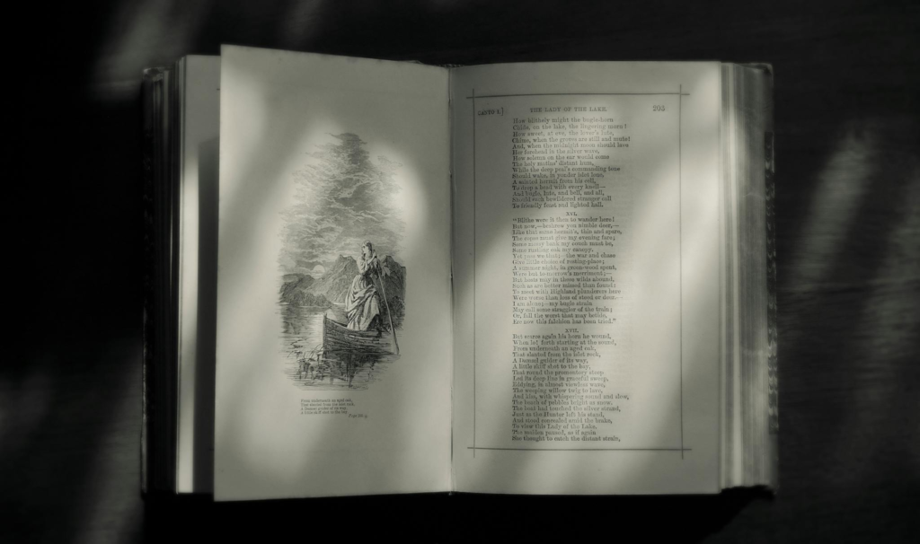An open book in grayscale showing poetry and a classic illustration, creating a vintage feel.